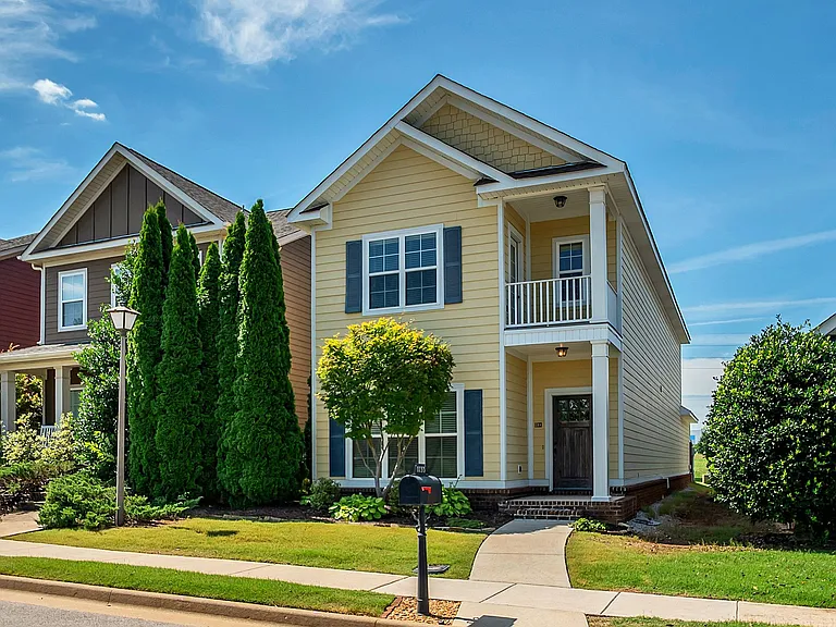 Yellow two story house with curb appeal