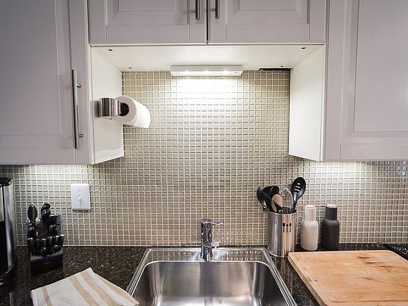 A close look at the chic backsplash and under cabinet lighti