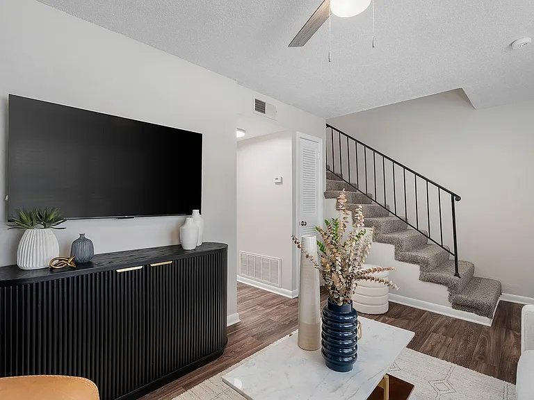 Spacious living room with hardwood-style flooring & ceiling fan