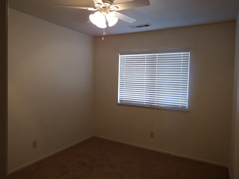 4th bedroom, large window, wood blinds and ceiling fan.