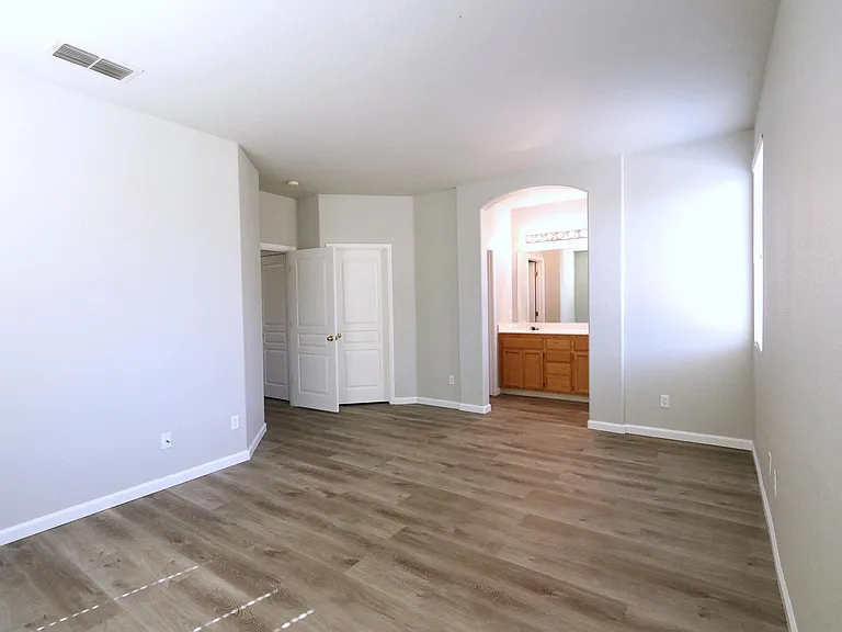 Master Bedroom with separate full bathroom, ceiling fan, window blinds, large walk-in closet