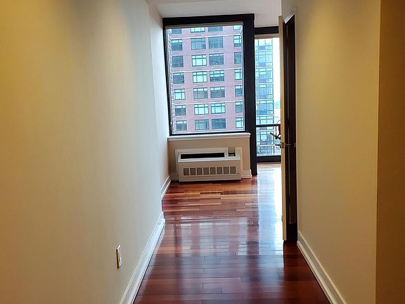 Entryway showcases stucco finish walls and cherry hardwood flooring