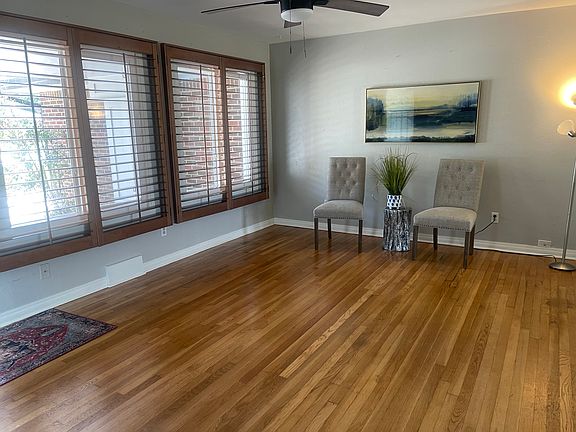 Living room with hardwood floors, plantation shutters and designer paints.