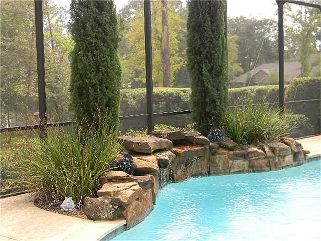 Moss rock waterfall provides a soothing sound as you are relaxing in your backyard oasis.