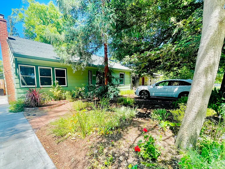 Another view of the front yard with mature landscape and shading redwood trees