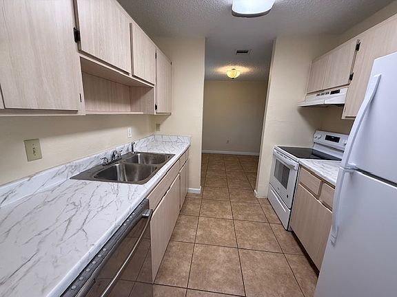 Galley Kitchen with new counter tops, new oven, and new refrigerator - Looking into dining area from garage