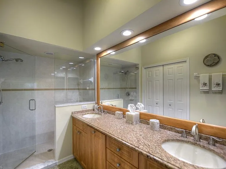 The master ensuite bath is just steps away, and the large window brings the beauty of nature right inside _ a perfect space to unwind after a sunny Naples day.