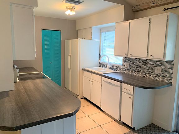 The kitchen features updated countertops and mosaic backsplash.