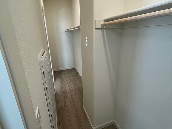 Large primary bedroom closet with two doors