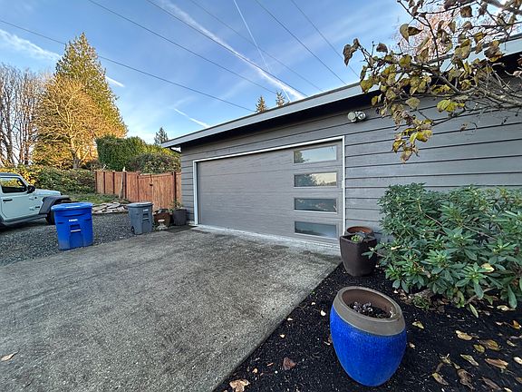 2 Car attached garage with extra parking in gravel area to left of driveway plus more parking behind double gated fence.