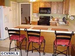 Kitchen open to den with breakfast bar