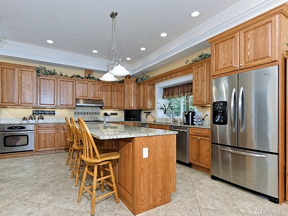 The kitchen features granite counters, oak cabinets, tumbled marble backsplash, ceramic tile floors, TWO stainless dishwashers(!), TWO ovens, and a 36" professional-style KitchenAide stainless steel duel fuel range. There's also an Insta-Hot, a built-in under counter microwave, under-counter lighting, and a pull-out trash/recycle center.