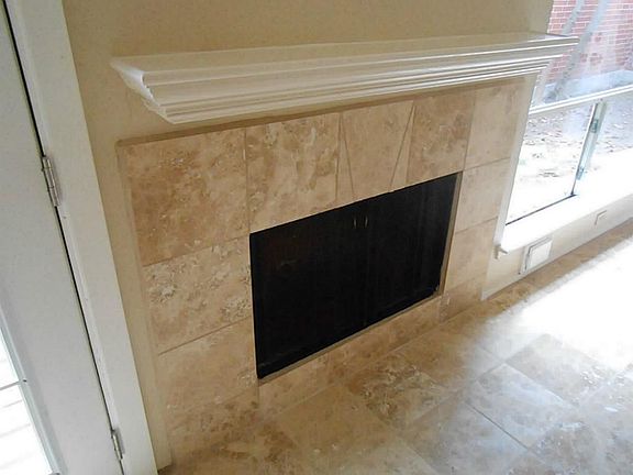 Tile Surround On The Fireplace Which Matches The Expansive Living Room Floors.
