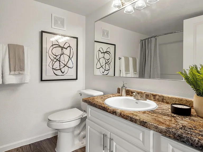 Bathrooms feature sprawling granite-style countertops with ample cabinetry storage below.