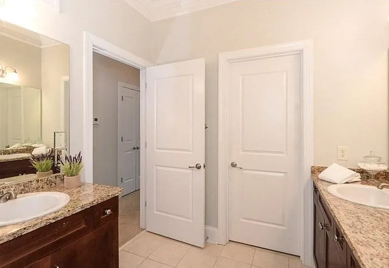 Dual vanity bathroom featuring wood cabinetry, light-toned countertops, and integrated sinks