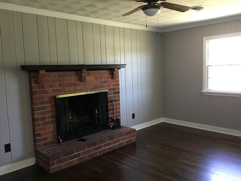 Freshly painted Den with fireplace and original hardwood flooring.