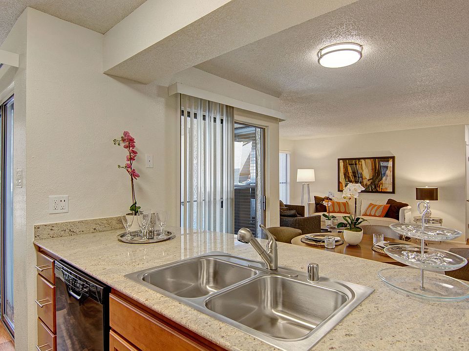 A kitchen with light cabinets and black appliances