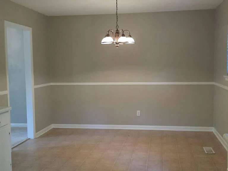 OLD PHOTO before cabinets and range were replaced last year but shows full layout with fridge. Kitchen has lots of counter space and storage, with a door to the back deck and fenced yard. Stairs lead down to laundry room and lower level.