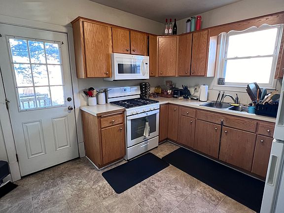 Kitchen has a new stove and microwave. Door leads to the deck and the large backyard.