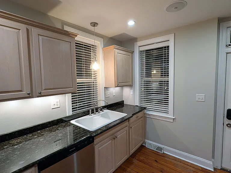 The kitchen has granite countertops. and a deep porcelain sink.