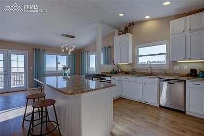 Recently refinished kitchen with drop in sink, granite slab counters, and stainl