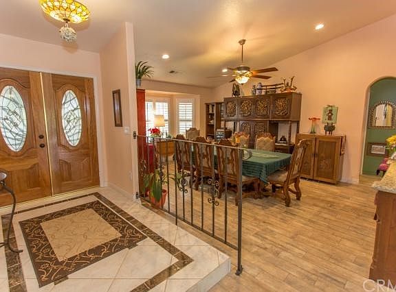 Double door entry, tiled foyer, custom wrought iron railing, separate dining room with tile floor, new windows with plantation shutters and ceiling fan.