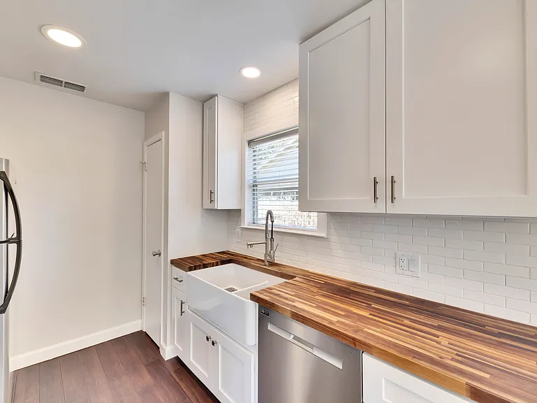 Modern Kitchen: featuring beautiful butcher block countertops, crisp white shaker style cabinets, and sleek stainless steel appliances.