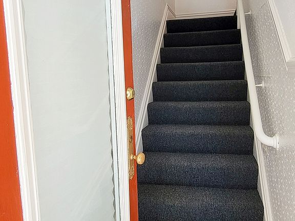 Front door and carpeted stairway