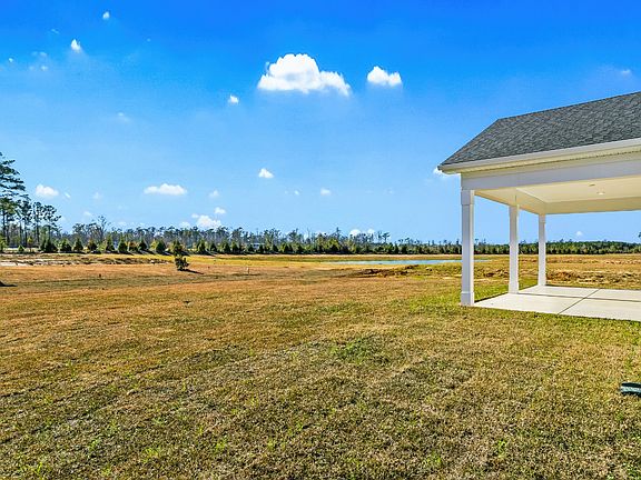 A peaceful Easton backyard featuring a covered porch and scenic pond views