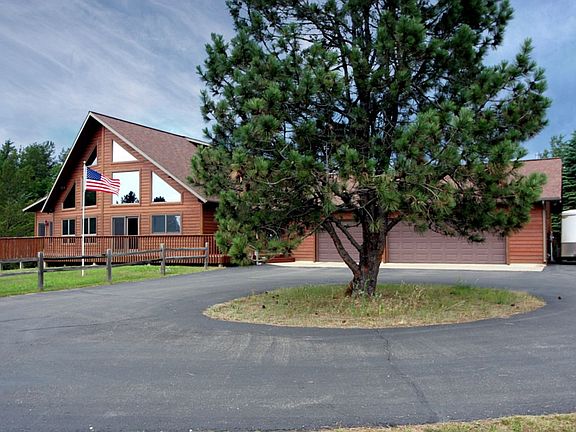 Circular drive with extra parking spaces and paved access to storage shed.