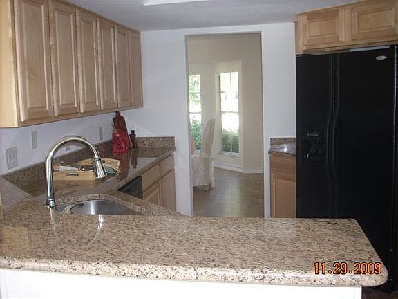 Kitchen features wood cabinetry and granite countertops.