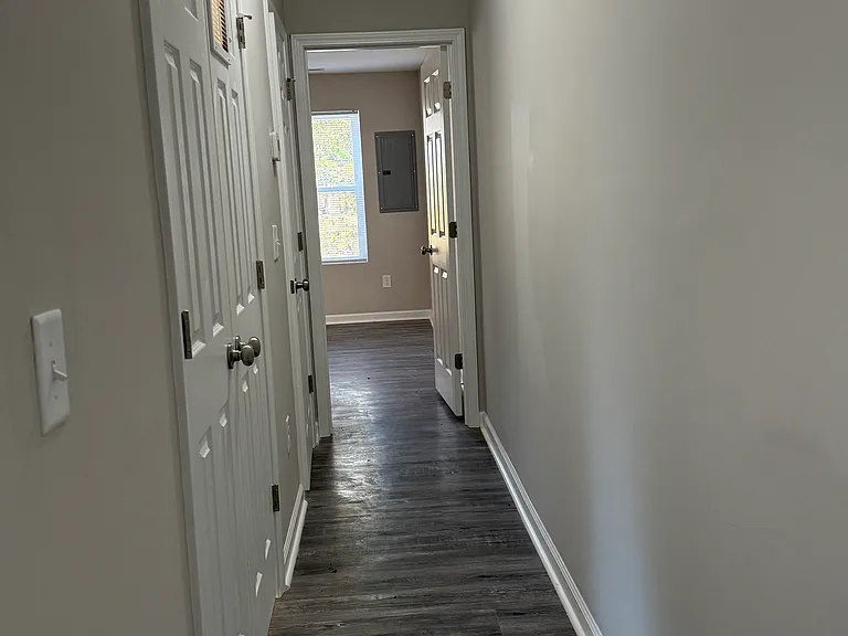 Hallway to primary bed, laundry, and half bath