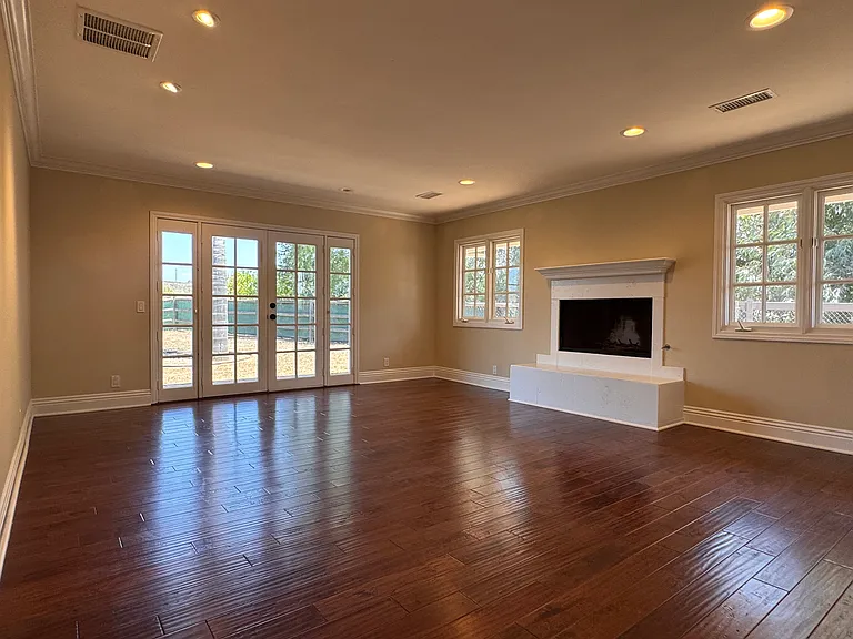 Primary bedroom with fireplace and french doors that open to backyard.
