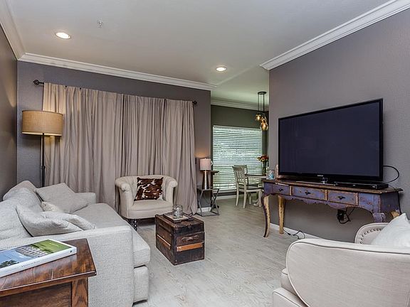 This perspective of the living area shows the openness to the dining area and kitchen.  Tile flooring, recessed lighting are just some of the amenities offered to the modern buyer.  Drapes are excluded from sale.