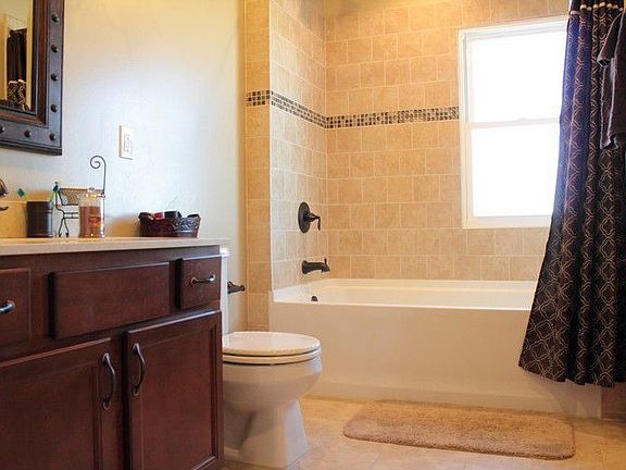 Features Ceramic tile throughout & custom glass mosaic inset in shower