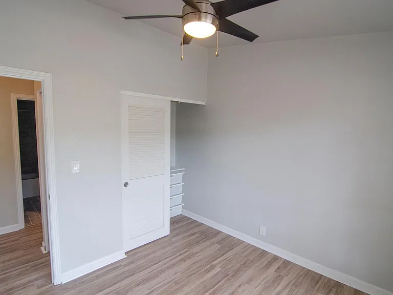 Second bedroom with A/C, ceiling fan, and custom closet system from The Container Store