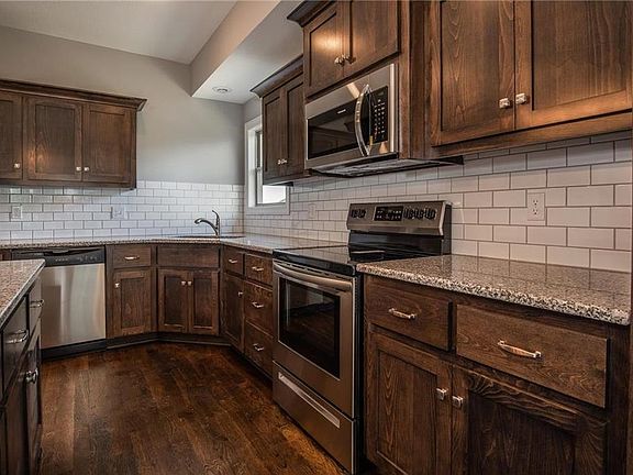 Granite counters and tile backsplash offer easy cleaning for this kitchen.