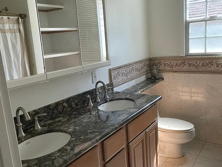 Bathroom granite dbl sinks with shower bath and lots of linen / towel cupboard
