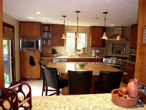 Updated kitchen with dual fuel stove, ceramic flooring and slider to deck.