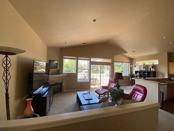 Open, great room with vaulted ceilings flows into kitchen and out to sunny balcony