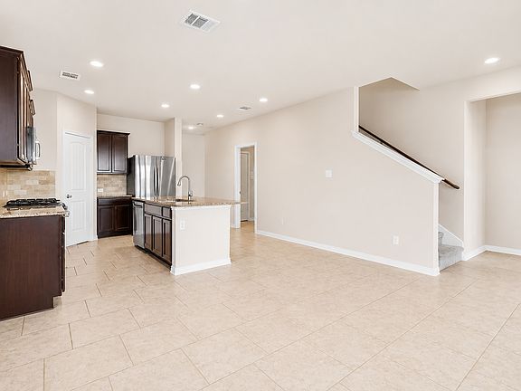 View of kitchen, dining area, and stairs to 2nd floor.