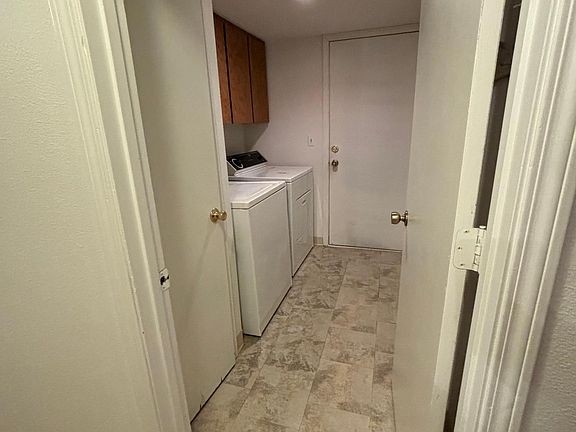 Laundry room connecting to two car garage and downstairs hallway
