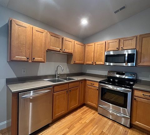Kitchen has real hardwood flooring and bright lights.
