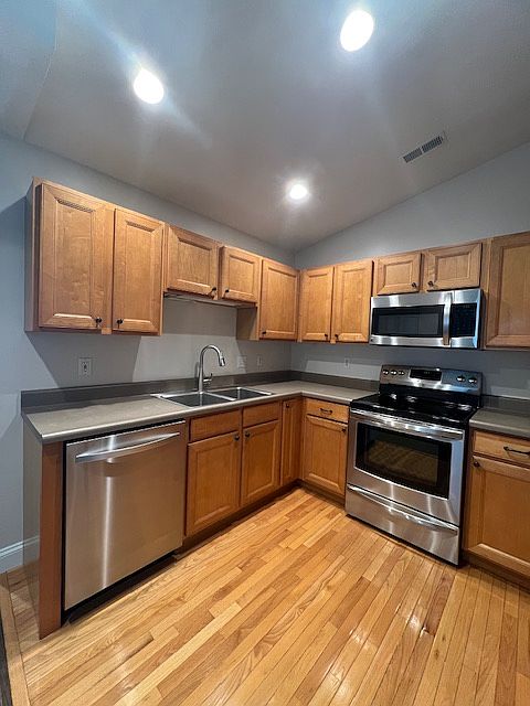 Kitchen has real hardwood flooring and bright lights.