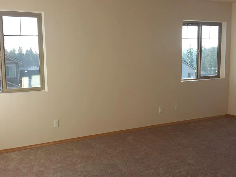 Expansive Primary Suite with views of the sunset. Cordless pull down/ pull up blinds are installed in each window for privacy.