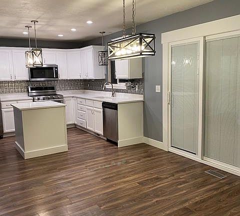 Kitchen and Dining. Newly remodeled quartz counter tops, island, sliding glass door to deck