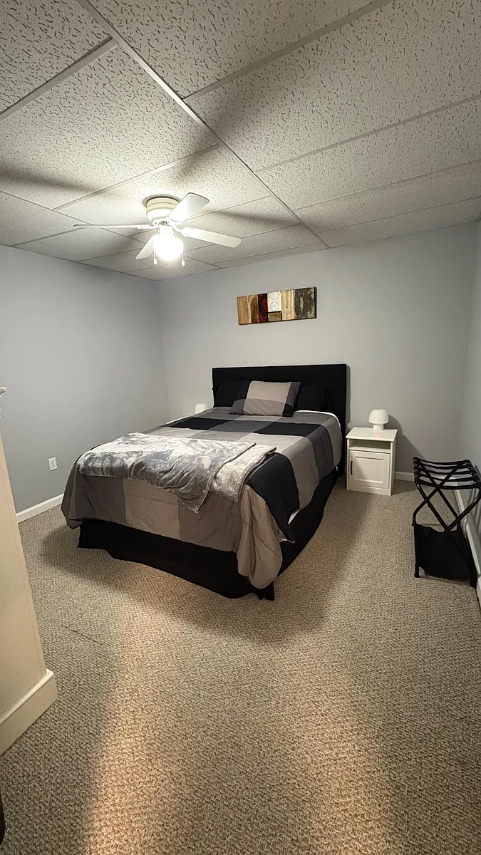 Carpeted bedroom with a full bed, nightstand lighting, and ceiling fanan easy, functional setup for comfortable living. - Stoneview Dr