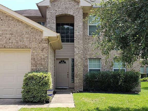 Mature shrubs adorns the front of the home creating an inviting entrance.