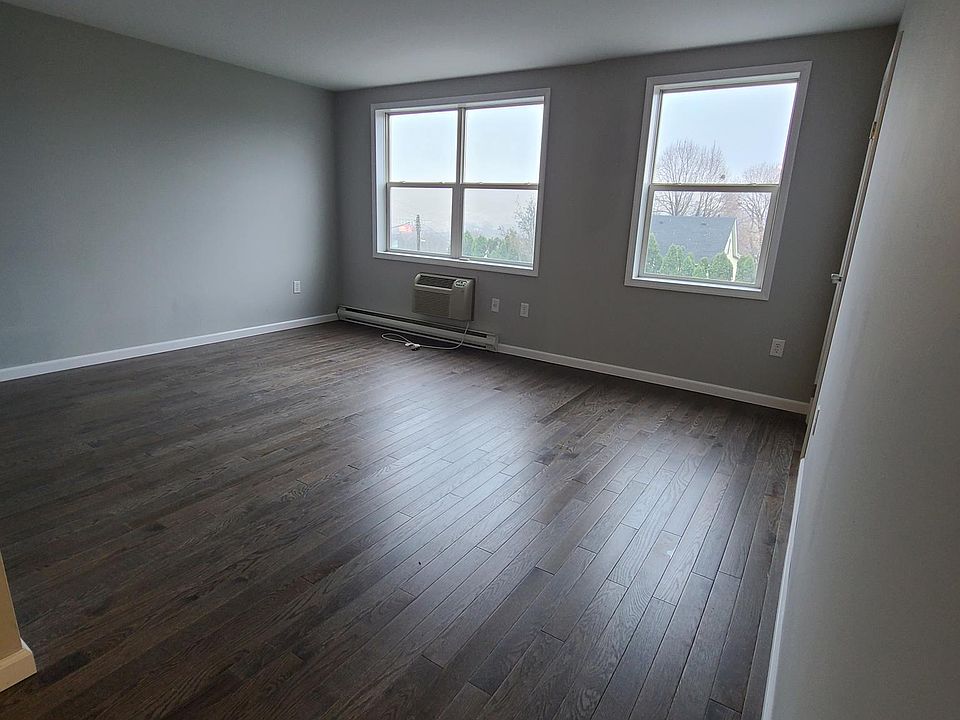 Large living room area, hardwood floors throughout, wall mounted air conditioning for the entire apartment.