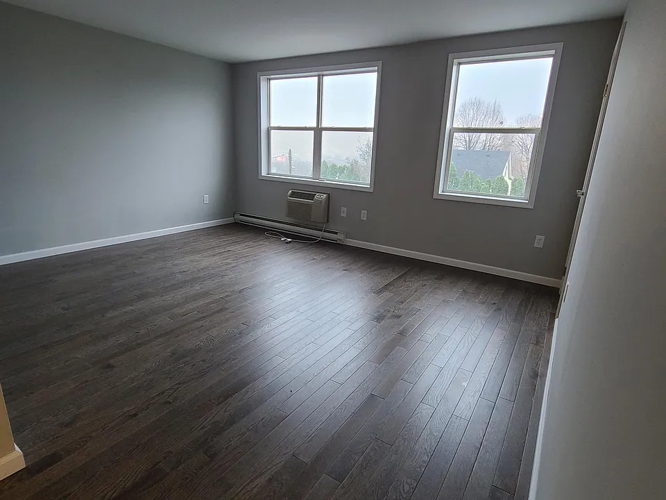 Large living room area, hardwood floors throughout, wall mounted air conditioning for the entire apartment.